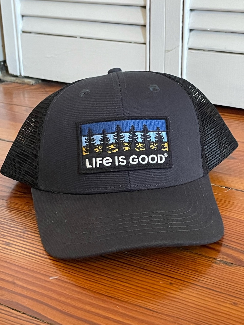 Life Is Good Black Trucker Hat with Blue and Yellow Pine Patch, One Size